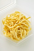 Home-made ribbon pasta in plastic container