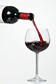 Pouring red wine into glass from bottle