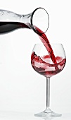 Pouring red wine into glass from carafe