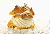 Cream puff with cream and icing sugar