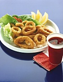 Deep-fried squid rings with mayonnaise, salad and lemon