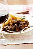 Venison ragout with potato noodles & thyme; red wine glass
