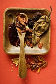 Various dried chili peppers in wooden bowl