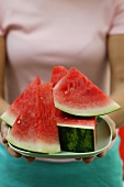 Frau hält Schale mit Wassermelonenschnitzen