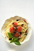 Spaghetti with cherry tomatoes, olives, cheese and basil