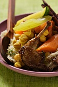 Roast pigeon with vegetables and cinnamon sticks on noodles