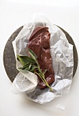 A slice of calf's liver with sage on paper