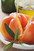 Pouring olive oil over tomatoes