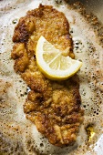 Frying escalope with lemon in frying pan
