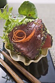 Raw tuna fillet with poppy seeds and salad garnish