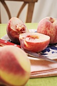 Fresh peaches, one halved, on plate
