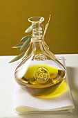 Olive oil in carafe with olive branch