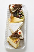 A selection of pieces of cake on white plate