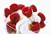 Fresh raspberries with cream in glass bowl
