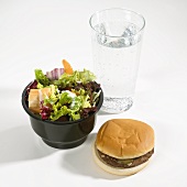 Hamburger, Salat und Glas Mineralwasser