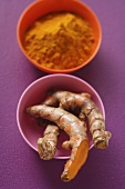 Turmeric roots and ground turmeric in bowls