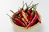 Fresh chili peppers, one opened, in basket