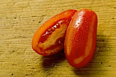 Grape tomato, halved, on wooden background