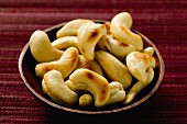 Toasted cashew kernels in wooden bowl