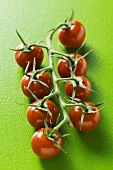 Cherry tomatoes on green background