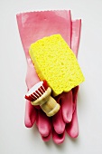Pink rubber gloves, sponge and brush