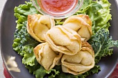 Deep-fried wontons with sweet and sour sauce (close-up)
