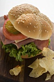 Ham, cheese, tomato and gherkin in sesame roll with crisps