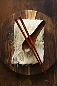 Thin rice noodles on wooden plate with chopsticks & spoon