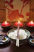 Bowl of rice in front of burning candles (Thailand)