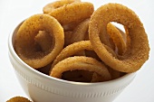 Deep-fried onion rings in white bowl