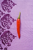 A red chili pepper on purple cloth