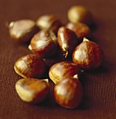 Sweet chestnuts on brown background