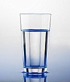 Wasserglas auf Wasserfläche stehend