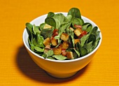 Corn salad with croutons and bacon in a small bowl