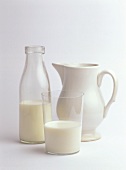 Milch in Glas, Flasche und Krug