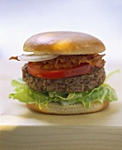 A hamburger with lettuce and bacon
