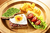 Steak tartare with fried egg and bread and chives