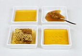 Four bowls of different types of honey