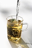 Hot water being poured into tea glass