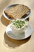 Cottage cheese in glass bowl with crispbread