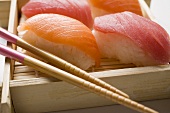 Nigiri sushi with chopsticks on bamboo mat