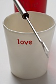 Beaker with the word 'love' and fondue fork