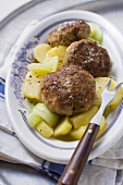 Burgers on potato and cucumber salad with meat fork