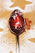 Spoon with jam and star outlined in icing sugar