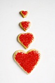 Four heart-shaped biscuits decorated with red sugar