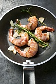 Bacon-wrapped king prawns in a frying pan