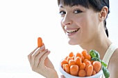 Young woman with baby carrots