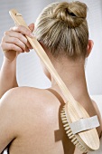 Back massage with long-handled bath brush