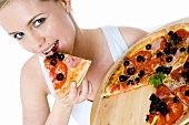 Junge Frau isst ein Stück Pizza