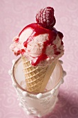 Ice cream with raspberry and raspberry sauce in wafer cone